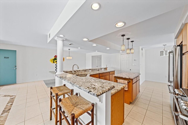 2101 Atlantic St Unit 531, Melbourne Beach, FL 32951 - kitchen with recessed lighting, light tile patterned floors, brown cabinetry, a spacious island, and a sink