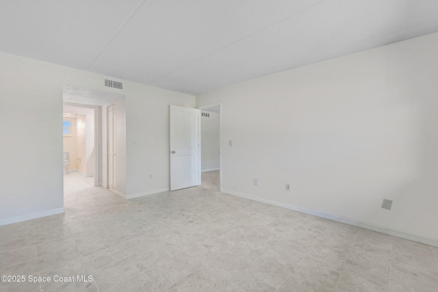 spare room featuring visible vents and baseboards