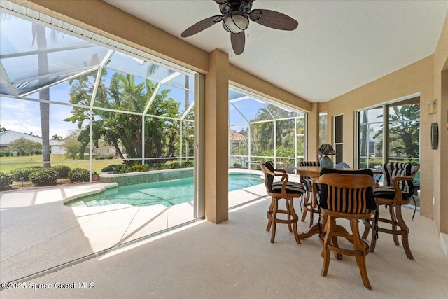 sunroom / solarium with a swimming pool and a ceiling fan