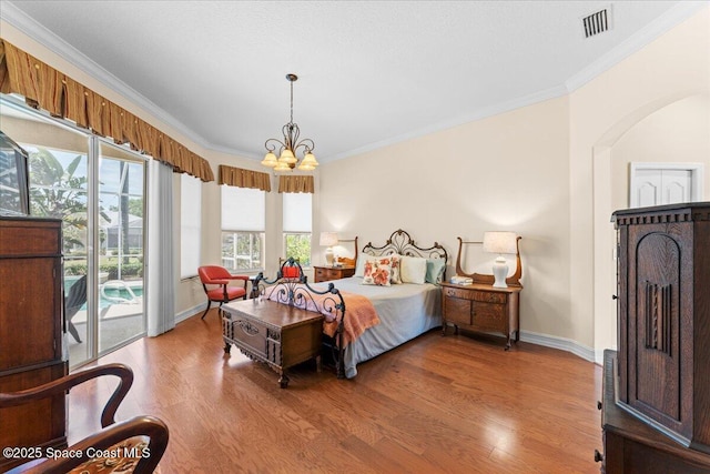 bedroom featuring visible vents, ornamental molding, light wood-style floors, baseboards, and a chandelier