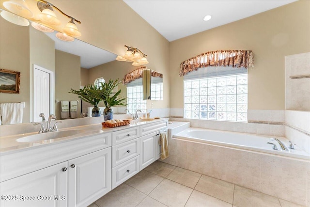 full bathroom featuring a sink, a bath, double vanity, and tile patterned flooring