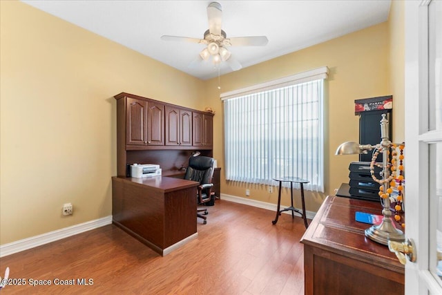 office area with light wood finished floors, baseboards, a ceiling fan, and a healthy amount of sunlight