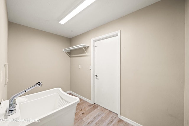 508 Carriage Rd, Indian Harbour Beach, FL 32937 - washroom featuring baseboards, light wood-type flooring, and a sink