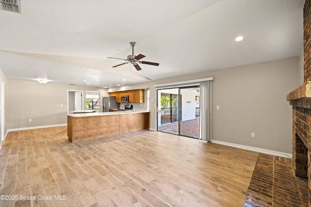 508 Carriage Rd, Indian Harbour Beach, FL 32937 - unfurnished living room featuring a wealth of natural light, visible vents, vaulted ceiling, and a brick fireplace
