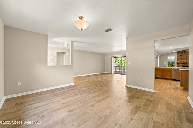 508 Carriage Rd, Indian Harbour Beach, FL 32937 - unfurnished living room featuring visible vents, a sink, lofted ceiling, light wood finished floors, and baseboards