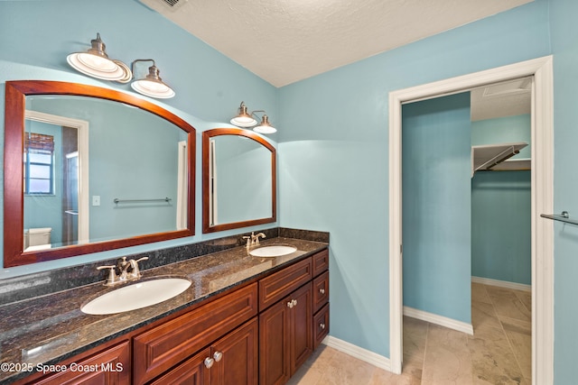 508 Carriage Rd, Indian Harbour Beach, FL 32937 - full bath featuring baseboards, double vanity, a textured ceiling, and a sink