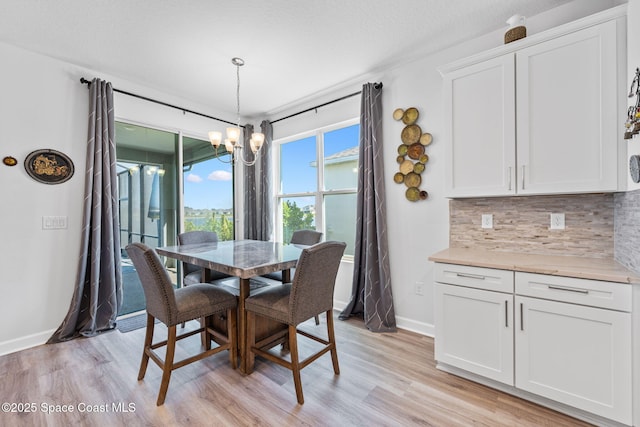 2631 Pinwherry St NW, Palm Bay, FL 32907 - dining area featuring a chandelier, light wood finished floors, and baseboards