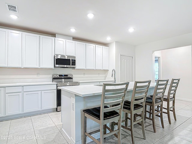 1314 Victory Palm Dr, Edgewater, FL 32132 - kitchen featuring stainless steel appliances, visible vents, a breakfast bar, and light tile patterned flooring