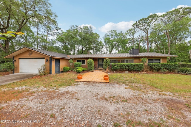 ranch-style house featuring concrete driveway, stucco siding, a garage, a standing seam roof, and metal roof