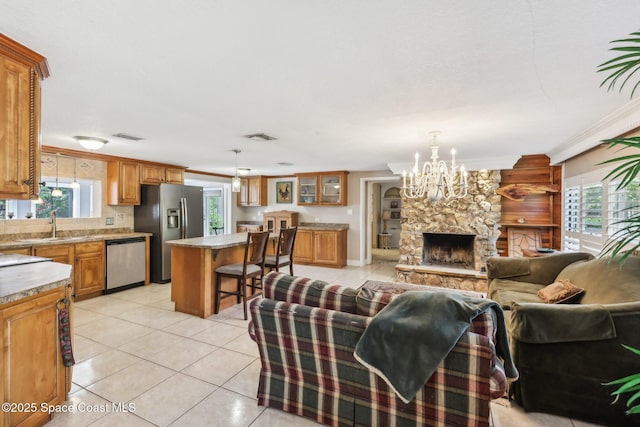living room with a chandelier, a wealth of natural light, light tile patterned floors, and visible vents