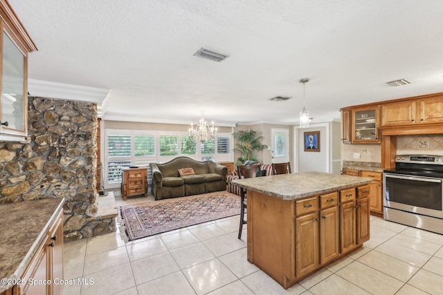 kitchen with stainless steel electric range oven, visible vents, a breakfast bar, crown molding, and brown cabinetry