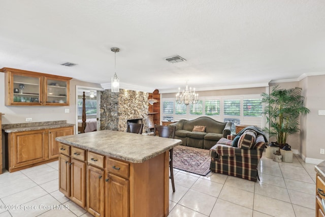 kitchen featuring brown cabinetry, open floor plan, light tile patterned flooring, and visible vents