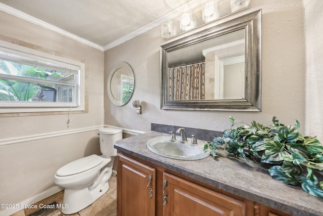 bathroom featuring baseboards, ornamental molding, toilet, a textured wall, and vanity