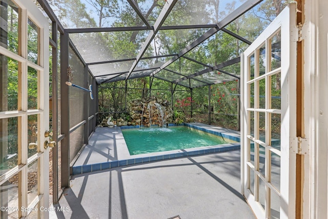 view of swimming pool with a patio area, glass enclosure, and a pool
