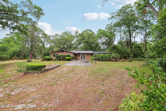 exterior space featuring a front yard, metal roof, and aphalt driveway