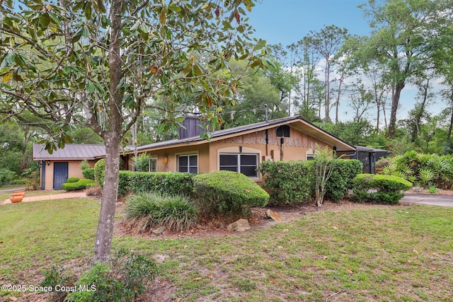 view of side of home with a yard and stucco siding