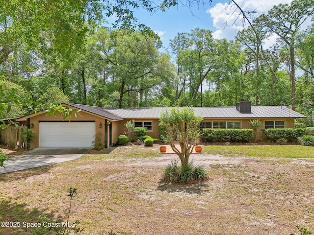 single story home featuring stucco siding, driveway, a garage, a standing seam roof, and metal roof
