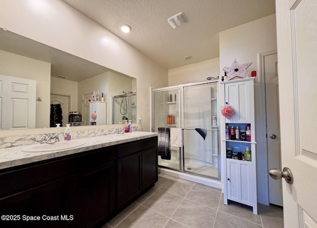 2507 Peralta Dr, Palm Bay, FL 32909 - full bath with a shower stall, tile patterned flooring, visible vents, a sink, and double vanity