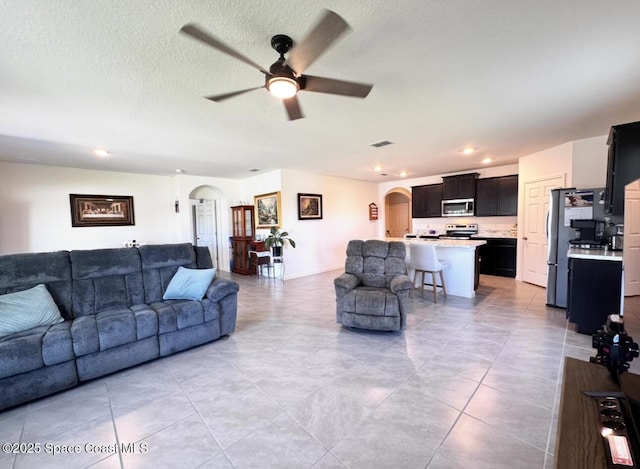 2507 Peralta Dr, Palm Bay, FL 32909 - living area with arched walkways, light tile patterned floors, a ceiling fan, and visible vents