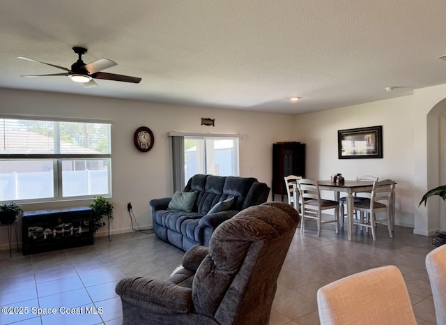 2507 Peralta Dr, Palm Bay, FL 32909 - tiled living room with arched walkways, baseboards, and a ceiling fan