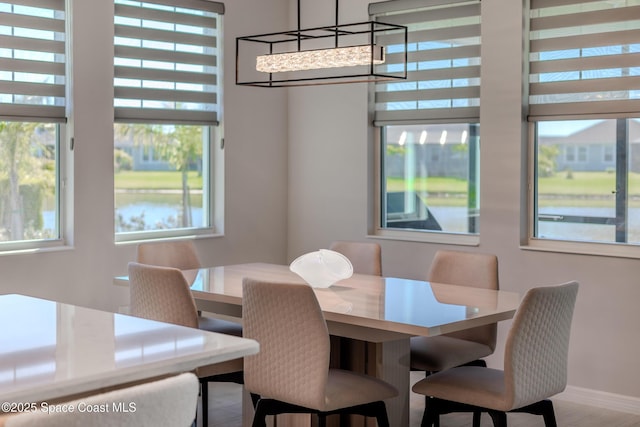 9527 Ebeko Ct, Melbourne, FL 32940 - dining area featuring plenty of natural light, a chandelier, and baseboards