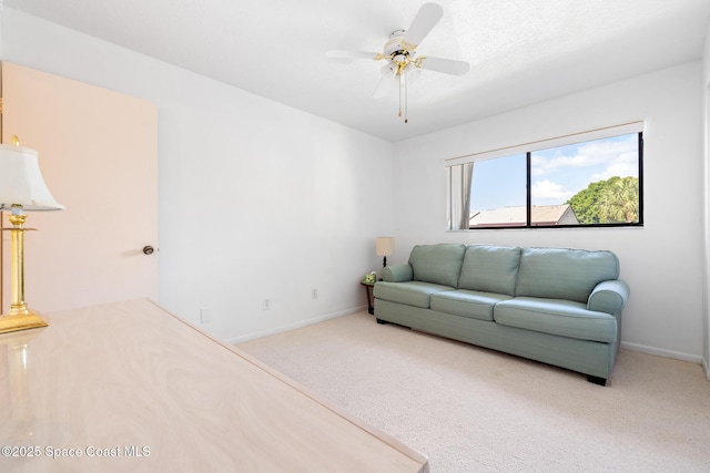 living room featuring baseboards, ceiling fan, and carpet