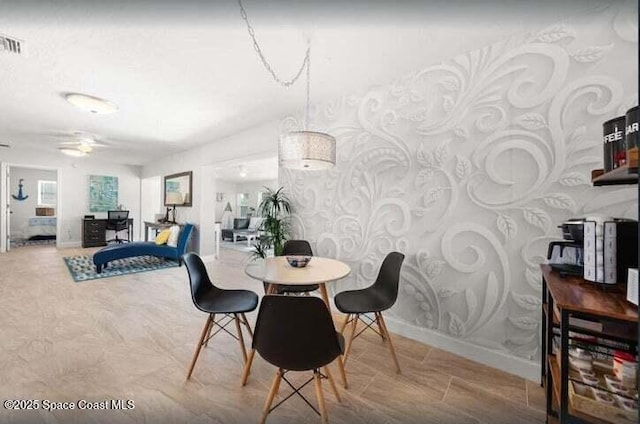 dining room featuring baseboards, a ceiling fan, and wallpapered walls