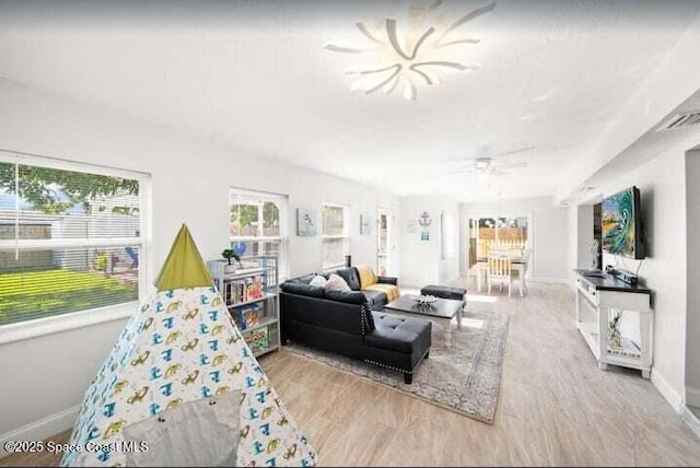 living room with visible vents, baseboards, a ceiling fan, and wood finished floors
