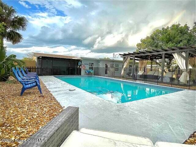 view of swimming pool featuring a pergola, a patio, fence, and a fenced in pool