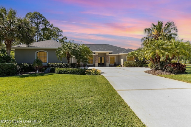 897 Yellow Wood Ct SE, Palm Bay, FL 32909 - view of front of home with a yard, concrete driveway, and stucco siding
