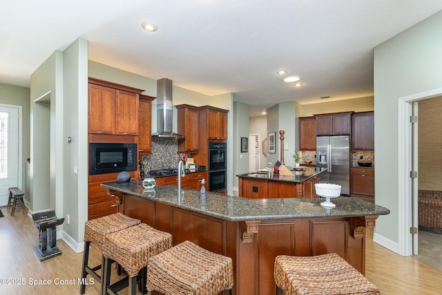 897 Yellow Wood Ct SE, Palm Bay, FL 32909 - kitchen featuring decorative backsplash, wall chimney range hood, black appliances, a large island, and light wood finished floors