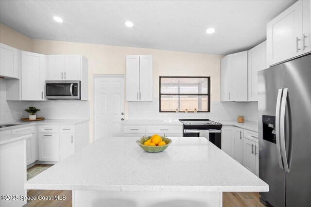 1800 Elmwood Dr, Melbourne, FL 32935 - kitchen with tasteful backsplash, recessed lighting, white cabinetry, light stone countertops, and stainless steel appliances