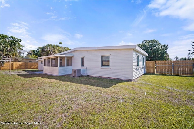 1800 Elmwood Dr, Melbourne, FL 32935 - rear view of property with a fenced backyard, central AC, a sunroom, and a lawn