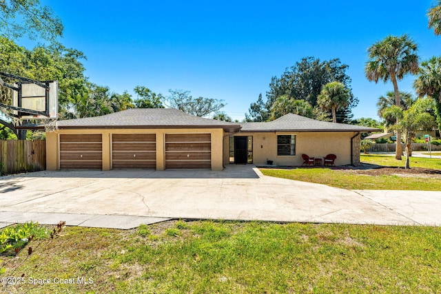 1475 S Oaks Dr, Merritt Island, FL 32952 - view of front of property with fence, stucco siding, an attached garage, concrete driveway, and a front yard