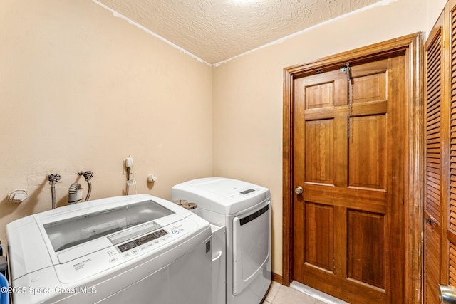 1475 S Oaks Dr, Merritt Island, FL 32952 - laundry room featuring washer and dryer, a textured ceiling, laundry area, and light tile patterned floors