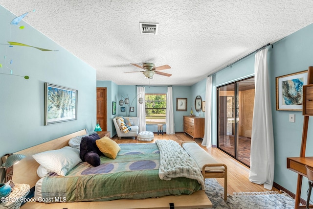1475 S Oaks Dr, Merritt Island, FL 32952 - bedroom with light wood-style floors, visible vents, a textured ceiling, and ceiling fan