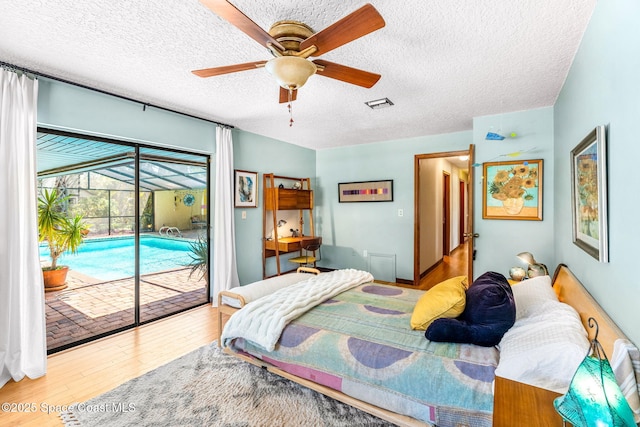 1475 S Oaks Dr, Merritt Island, FL 32952 - bedroom featuring wood finished floors, visible vents, a textured ceiling, access to outside, and ceiling fan