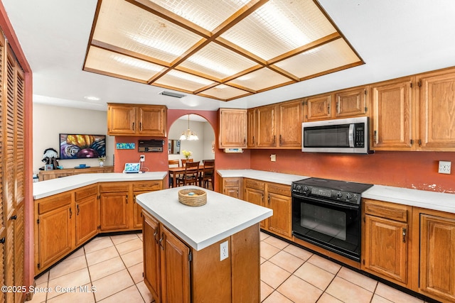 1475 S Oaks Dr, Merritt Island, FL 32952 - kitchen featuring light countertops, visible vents, stainless steel microwave, a center island, and black electric range