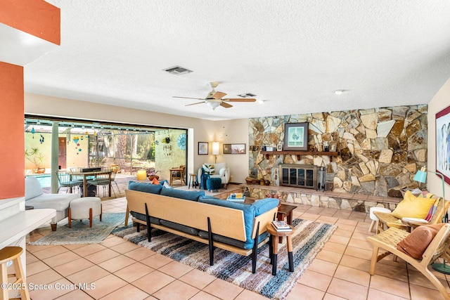 1475 S Oaks Dr, Merritt Island, FL 32952 - living room featuring tile patterned floors, visible vents, a ceiling fan, a fireplace, and a textured ceiling