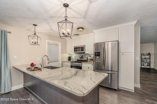 100 Barbados Dr, Merritt Island, FL 32952 - kitchen featuring white cabinets, stainless steel appliances, a notable chandelier, and dark wood-style flooring