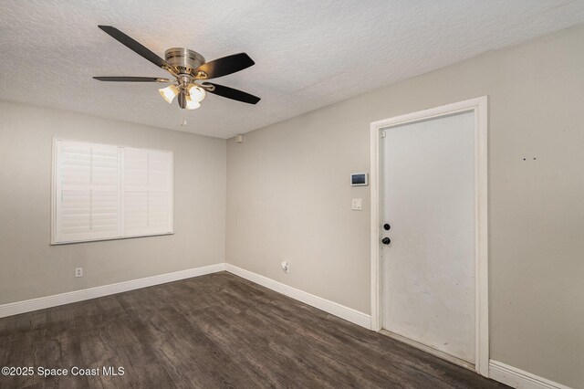 100 Barbados Dr, Merritt Island, FL 32952 - empty room featuring dark wood finished floors, baseboards, a ceiling fan, and a textured ceiling