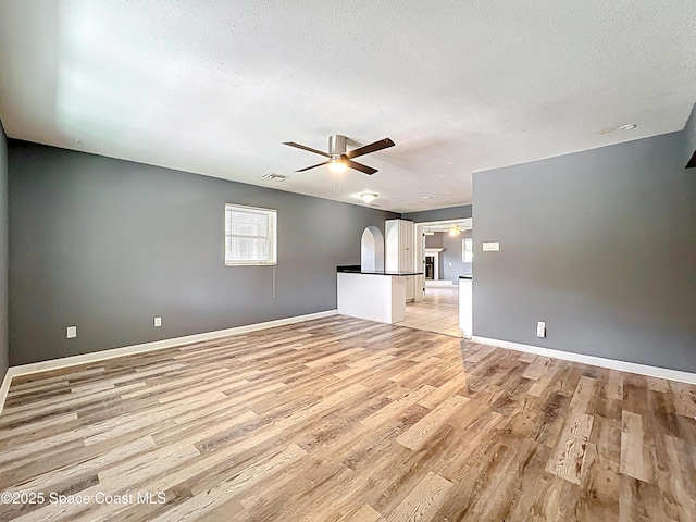 2543 Hathaway Dr, Cocoa, FL 32926 - spare room with ceiling fan, light wood finished floors, a textured ceiling, arched walkways, and baseboards