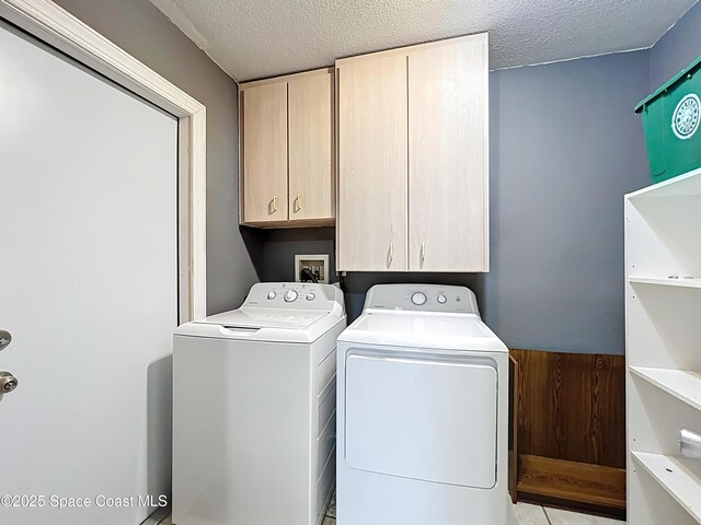 2543 Hathaway Dr, Cocoa, FL 32926 - laundry area featuring cabinet space, washing machine and clothes dryer, and a textured ceiling