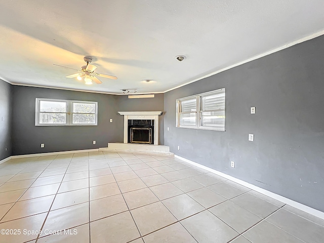 2543 Hathaway Dr, Cocoa, FL 32926 - unfurnished living room with a ceiling fan, healthy amount of natural light, light tile patterned floors, a premium fireplace, and crown molding