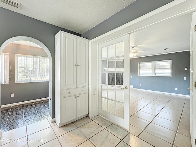 2543 Hathaway Dr, Cocoa, FL 32926 - spare room with arched walkways, light tile patterned floors, a ceiling fan, baseboards, and a textured ceiling