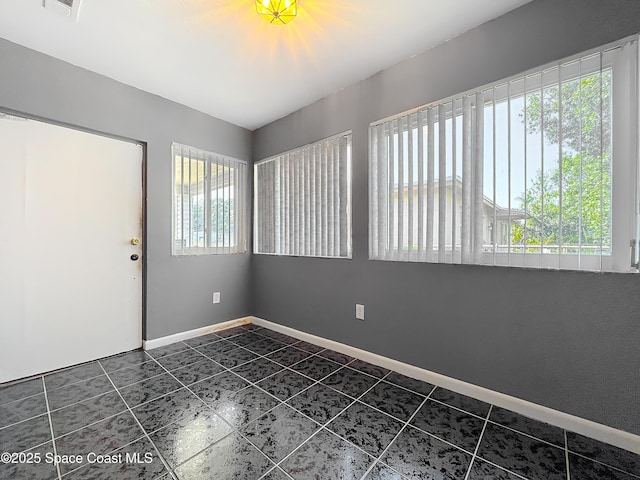 2543 Hathaway Dr, Cocoa, FL 32926 - empty room featuring dark tile patterned floors and baseboards