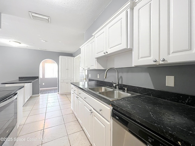 2543 Hathaway Dr, Cocoa, FL 32926 - kitchen featuring appliances with stainless steel finishes, a sink, arched walkways, white cabinetry, and light tile patterned floors