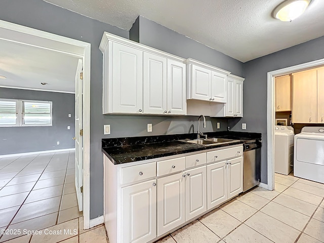 2543 Hathaway Dr, Cocoa, FL 32926 - kitchen featuring washer and clothes dryer, a sink, stainless steel dishwasher, white cabinetry, and light tile patterned floors