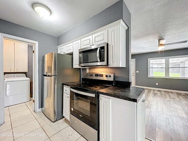 2543 Hathaway Dr, Cocoa, FL 32926 - kitchen with appliances with stainless steel finishes, washer / clothes dryer, dark countertops, a textured ceiling, and white cabinets