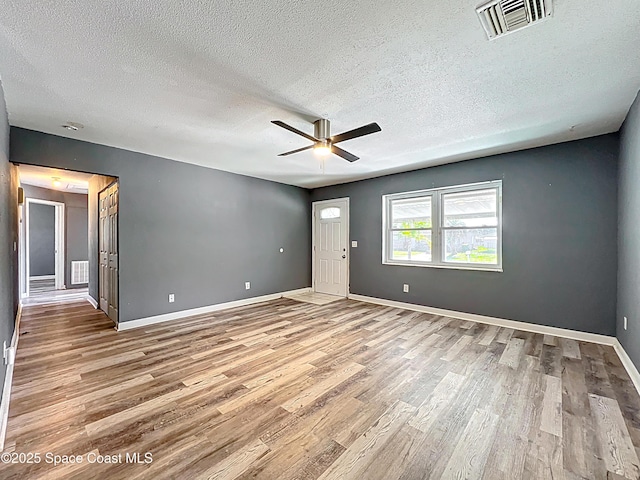 2543 Hathaway Dr, Cocoa, FL 32926 - empty room with wood finished floors, a textured ceiling, ceiling fan, and baseboards